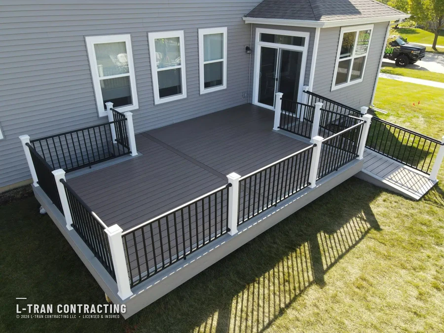Ground-level deck with white railings and covered seating area