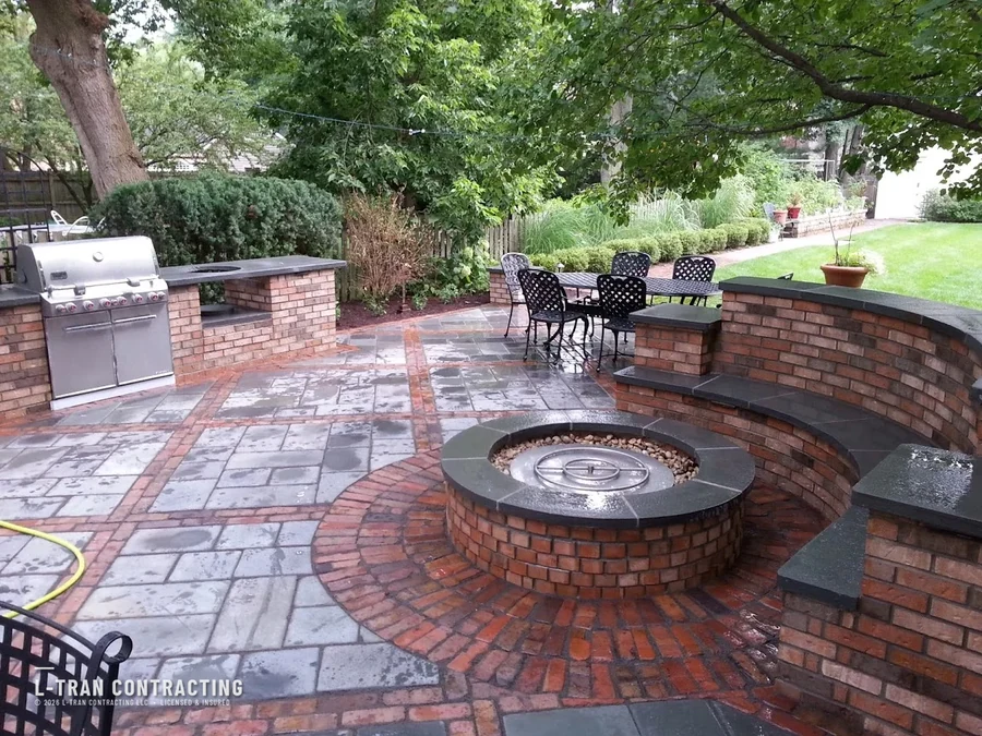 Brick patio with fire pit, outdoor kitchen, and curved seating wall