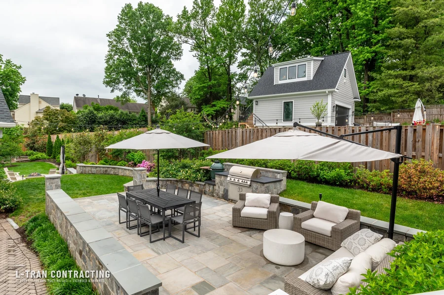 Aerial view of paver patio with pergola, umbrellas, and outdoor kitchen