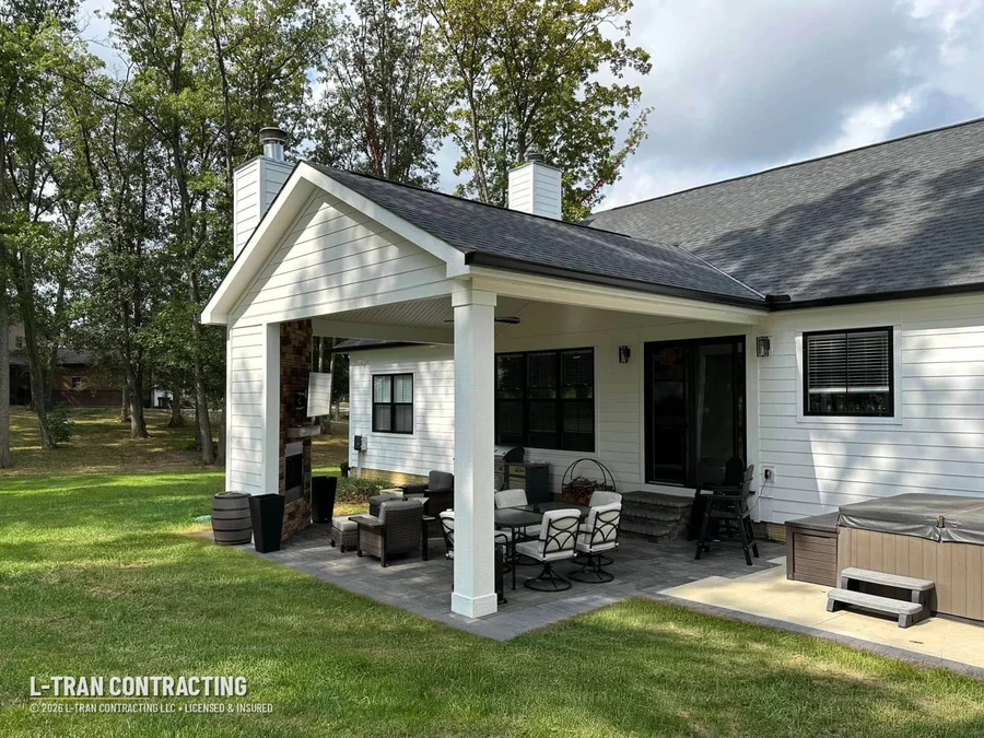 Covered porch with stone fireplace and hot tub
